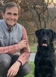 Jim Kessler sitting with a black labrador